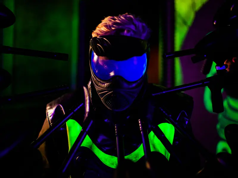 Player with mask and marker in the paintball arena